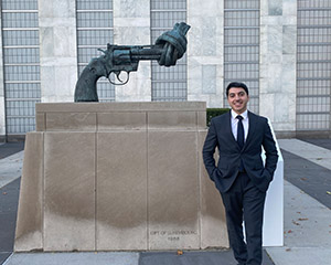 Almuntaser Albalawi vor Statue von Pistole mit verknotetem Lauf