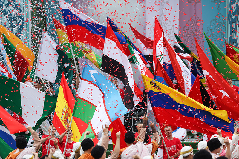 Flaggen der BRICS-Staaten werden im Konfetti-Regen geschwenkt.