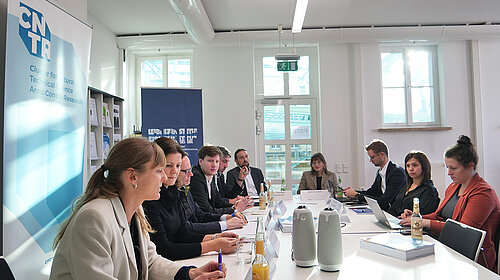 Gruppe von Personen, die an einem Tisch sitzen und alle in die gleiche Richtung schauen, vor CNTR- und PRIF-Roll-ups CNTR-Forscher*innen beim virtuellen Meeting mit dem Referat für Forschungssicherheit und Investitionsprüfung des Bundesministeriums für Bildung und Forschung