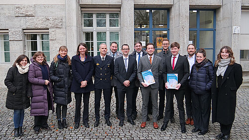 Gruppe von Personen in einem Innenhof stehend