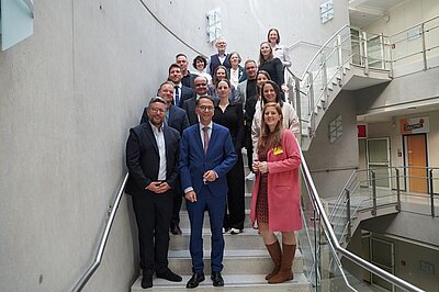 Group photo: 17 people standing on a staircase