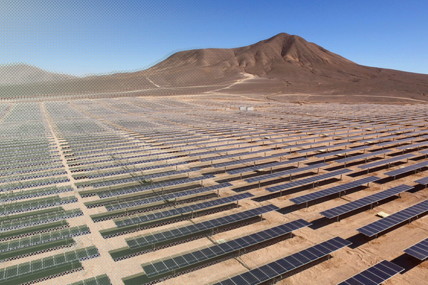 Landschaftsfotografie von blauen Solarmodulen, im Hintergrund ist ein karger Berg zu sehen.