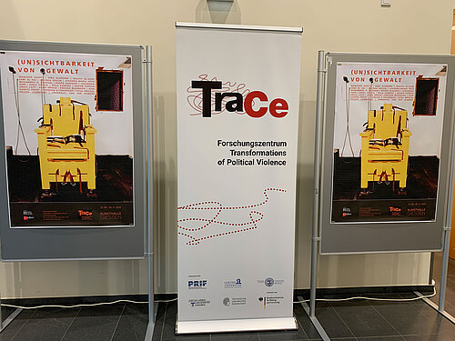 The TraCe rollup stands between two exhibition posters.