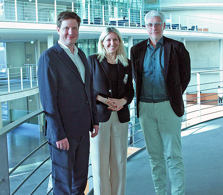 Göttsche, Schneckener, and Launert are standing side by side, smiling at the camera.